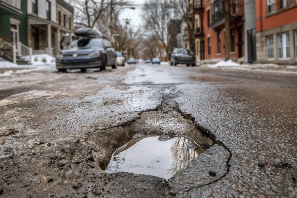 Large deep pothole in Montreal street, Canada. Auto Body Repair